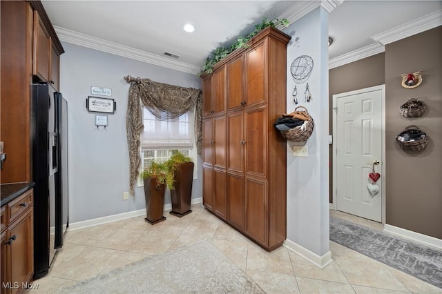 kitchen with crown molding, dark countertops, brown cabinets, and light tile patterned flooring