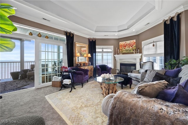 carpeted living area featuring a healthy amount of sunlight and crown molding
