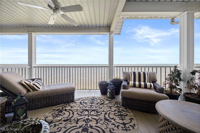 sunroom / solarium featuring a beach view and a water view