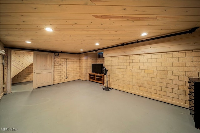 finished basement featuring recessed lighting and brick wall