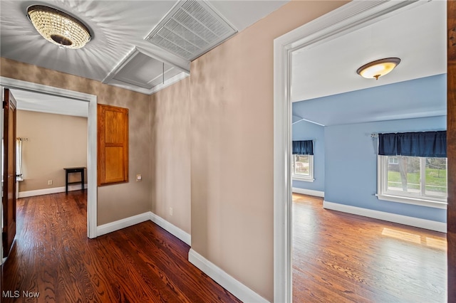 hallway featuring dark wood-style floors and baseboards
