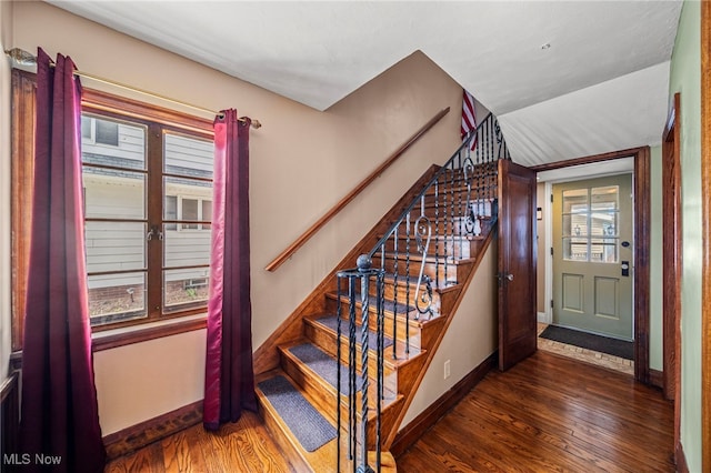 staircase featuring wood finished floors and baseboards