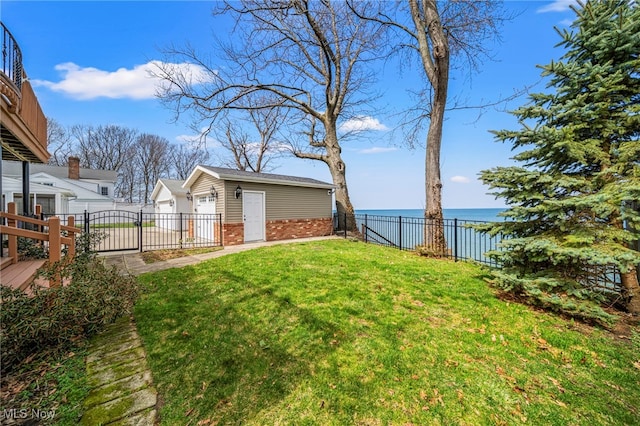 view of yard featuring an outdoor structure, a water view, and a garage