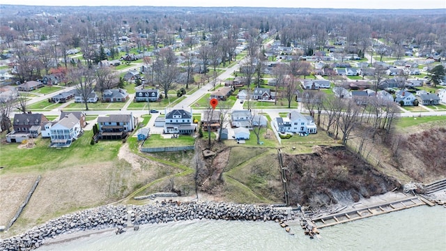 aerial view of property and surrounding area featuring nearby suburban area and a large body of water