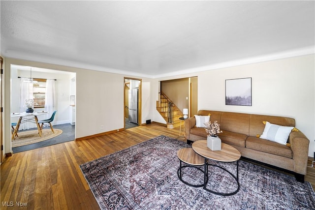 living area with stairway, wood-type flooring, and baseboards