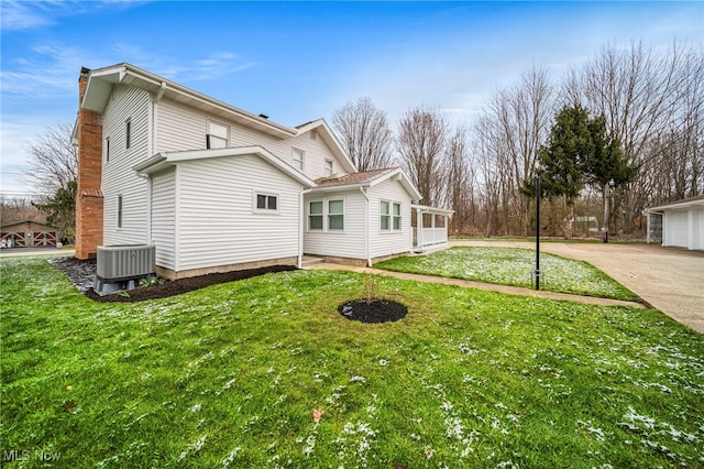 6232 S Ridge Rd W, Geneva, OH 44041 - view of side of home featuring central AC unit, a chimney, a lawn, and concrete driveway