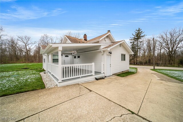 6232 S Ridge Rd W, Geneva, OH 44041 - view of home's exterior with covered porch, a chimney, and a yard