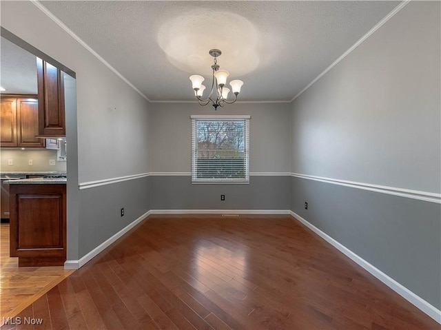 101 Keyser St, Marietta, OH 45750 - unfurnished dining area featuring a chandelier, baseboards, crown molding, and wood finished floors