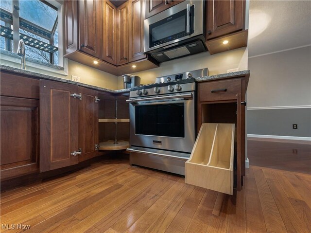 101 Keyser St, Marietta, OH 45750 - kitchen featuring stainless steel appliances, light wood-style flooring, baseboards, and dark stone counters