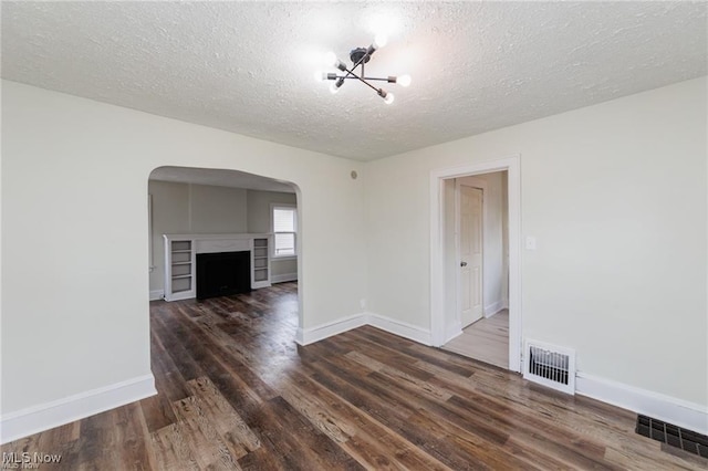 575 Fernwood Dr, Akron, OH 44320 - interior space featuring visible vents, arched walkways, a chandelier, and wood finished floors