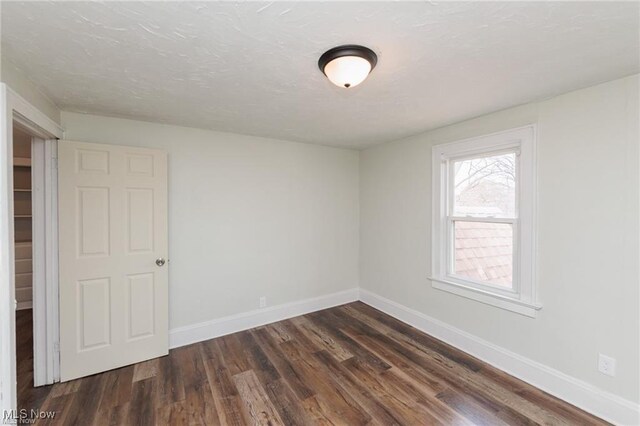 575 Fernwood Dr, Akron, OH 44320 - empty room featuring dark wood-type flooring, baseboards, and a textured ceiling