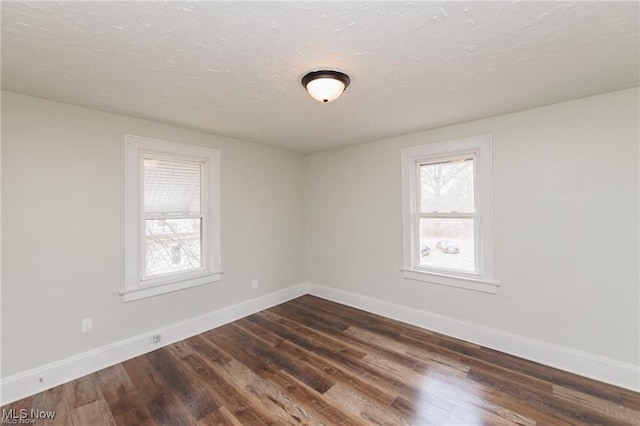 575 Fernwood Dr, Akron, OH 44320 - spare room with dark wood-style flooring, baseboards, and a textured ceiling