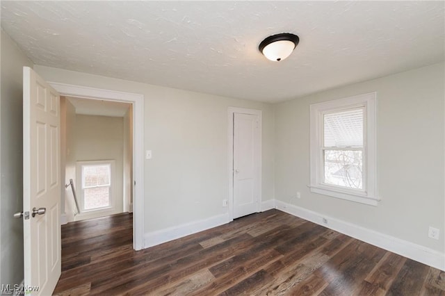 575 Fernwood Dr, Akron, OH 44320 - unfurnished room featuring dark wood-type flooring, baseboards, and a textured ceiling