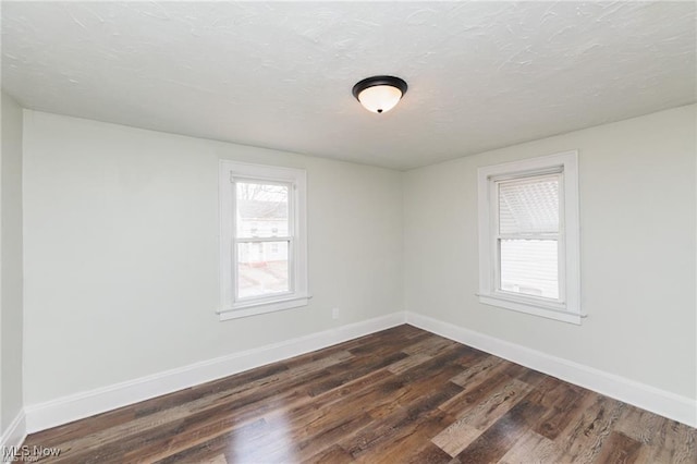 575 Fernwood Dr, Akron, OH 44320 - spare room with dark wood-type flooring, a textured ceiling, and baseboards