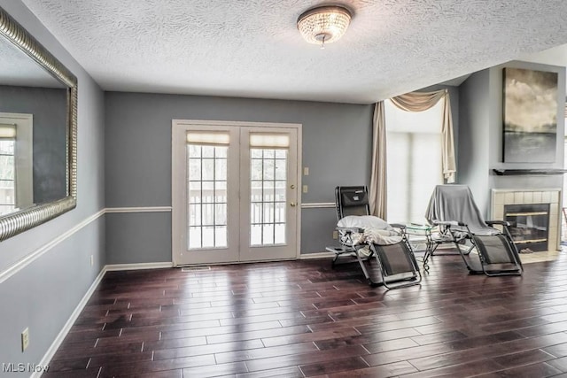 4989 Belden Park Dr NW, North Canton, OH 44720 - sitting room featuring a textured ceiling, a tile fireplace, wood finished floors, french doors, and baseboards