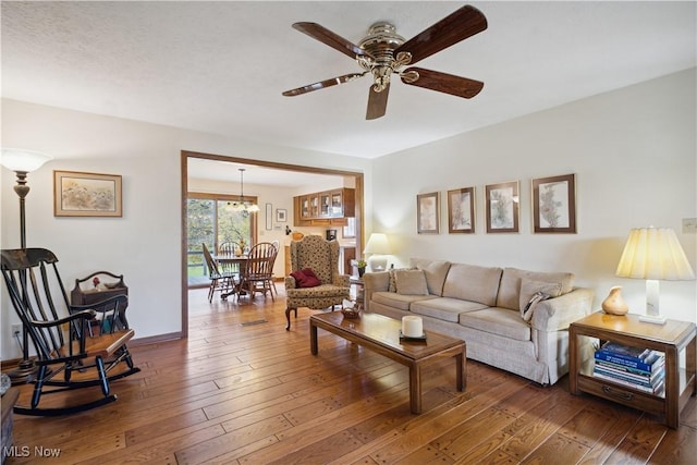 living area with hardwood / wood-style flooring, baseboards, and ceiling fan