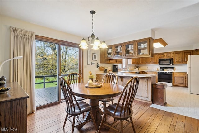 dining space with light wood-style flooring and an inviting chandelier
