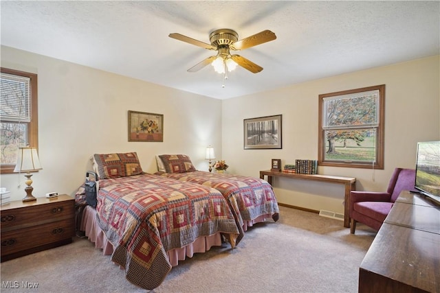 carpeted bedroom featuring visible vents and ceiling fan