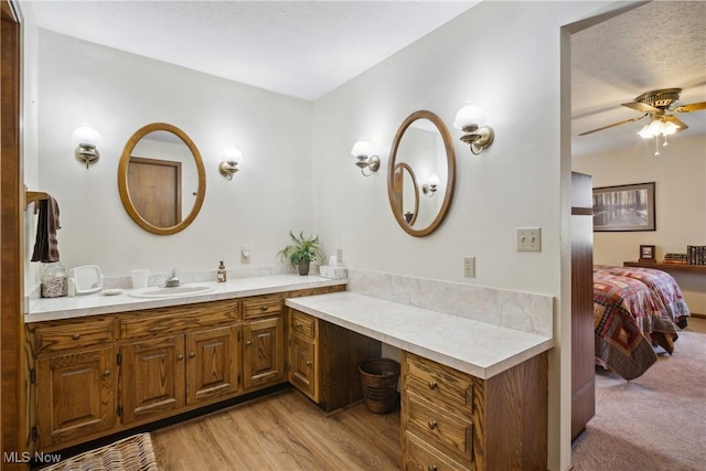 ensuite bathroom with vanity, ensuite bathroom, wood finished floors, and ceiling fan