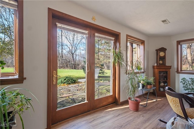 doorway to outside with light wood-style flooring and visible vents