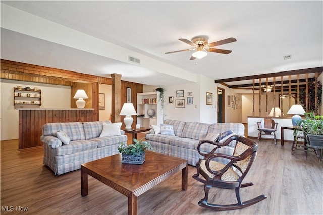 living area featuring visible vents, a ceiling fan, and wood finished floors