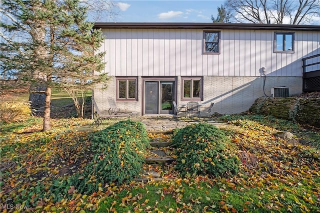 back of house featuring a patio, brick siding, and central AC unit