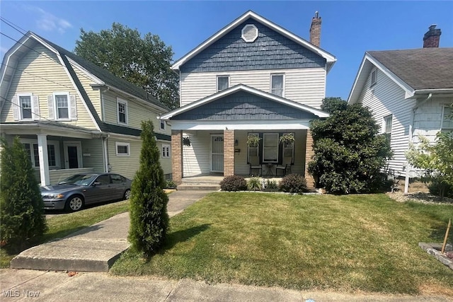 view of front of house featuring a front yard, covered porch, and a chimney