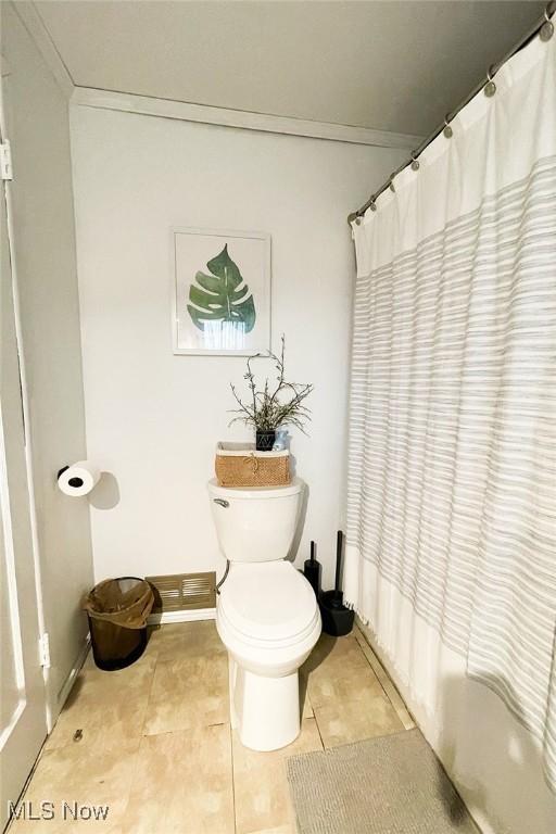 full bath with crown molding, toilet, curtained shower, and tile patterned flooring