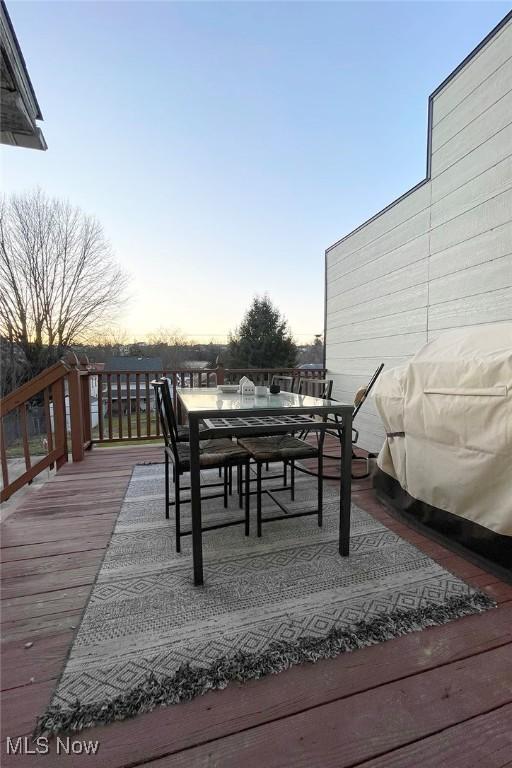 deck with a grill and outdoor dining area