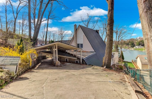 166 Cheyenne Trl, Malvern, OH 44644 - view of front of home with a chimney, driveway, a water view, and a carport