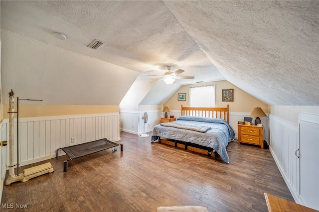 2457 Sheffield Rd, Jefferson, OH 44047 - bedroom with a textured ceiling, lofted ceiling, wood finished floors, a wainscoted wall, and a ceiling fan