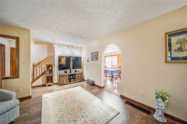 2457 Sheffield Rd, Jefferson, OH 44047 - living room featuring arched walkways, stairs, wood finished floors, baseboards, and a textured ceiling