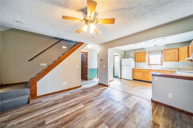 2457 Sheffield Rd, Jefferson, OH 44047 - kitchen with freestanding refrigerator, light wood-style flooring, baseboards, light countertops, and a textured ceiling