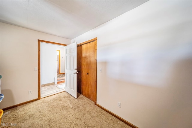 2457 Sheffield Rd, Jefferson, OH 44047 - unfurnished bedroom featuring light carpet, baseboards, and a closet
