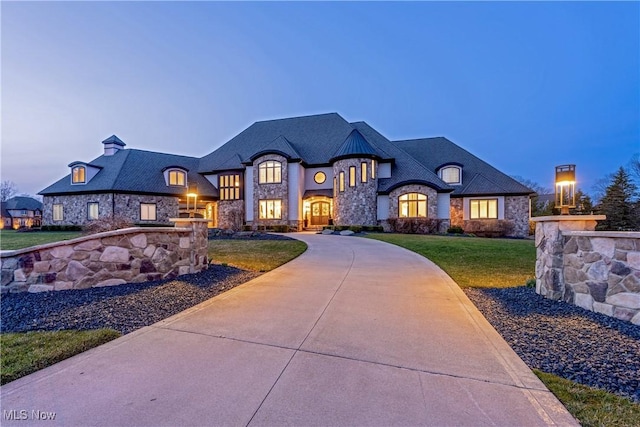 3377 E Galloway Dr, Richfield, OH 44286 - french country style house featuring a front yard, curved driveway, stone siding, and a chimney