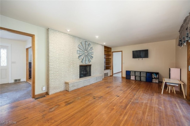 100 Crestwood Cir, Marietta, OH 45750 - unfurnished living room featuring a brick fireplace, hardwood / wood-style flooring, recessed lighting, built in shelves, and baseboards