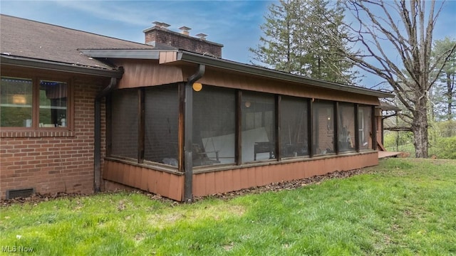 100 Crestwood Cir, Marietta, OH 45750 - view of side of property with a sunroom, a chimney, brick siding, and a lawn