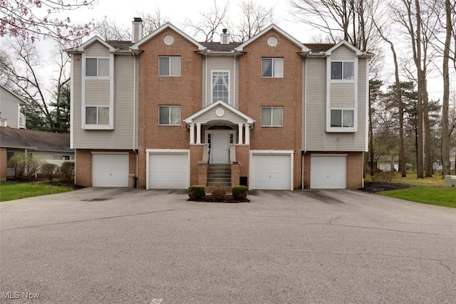 362 Village Pointe Dr, Akron, OH 44313 - townhome / multi-family property featuring brick siding, driveway, a chimney, and an attached garage