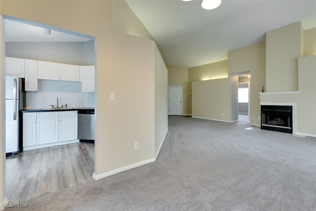 362 Village Pointe Dr, Akron, OH 44313 - unfurnished living room featuring baseboards, high vaulted ceiling, and light carpet