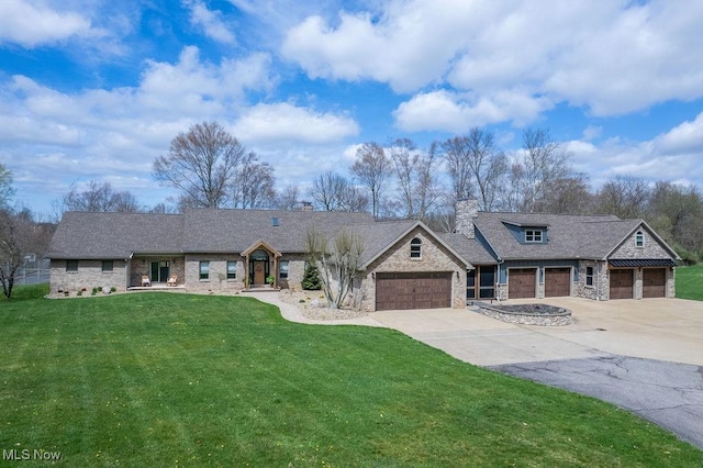 view of front of house with a front yard, driveway, stone siding, and an attached garage