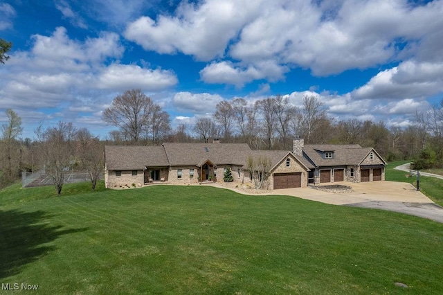 view of front facade with concrete driveway, a chimney, stone siding, a front yard, and a garage
