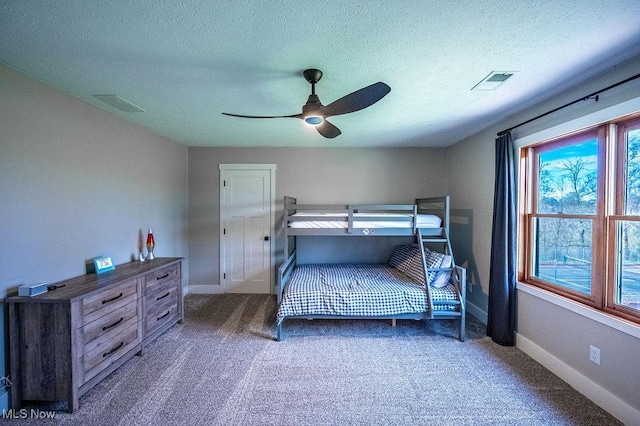 bedroom featuring a textured ceiling, baseboards, visible vents, and carpet floors