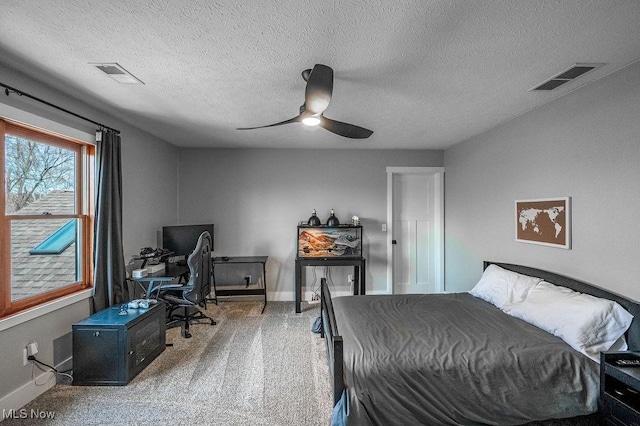 carpeted bedroom featuring visible vents, baseboards, a ceiling fan, and a textured ceiling