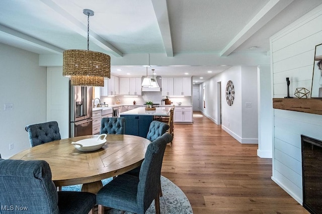 dining room with dark wood-style flooring, beamed ceiling, baseboards, and recessed lighting