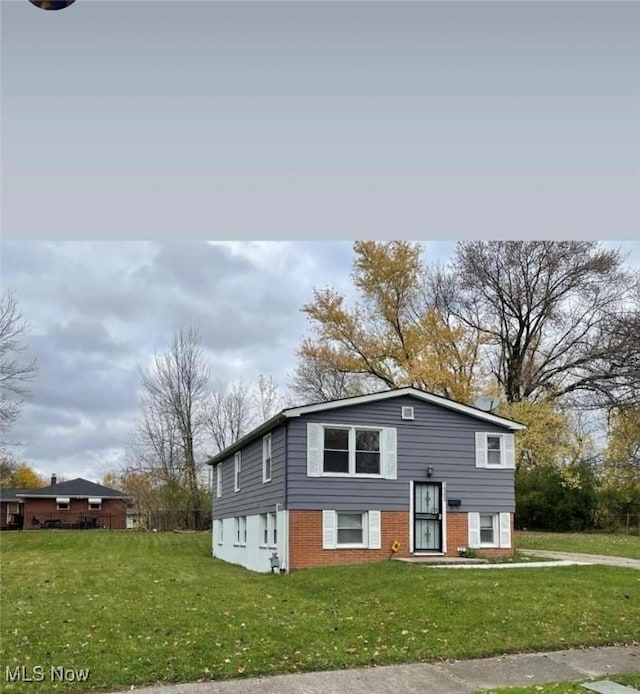 view of front facade featuring brick siding and a front lawn