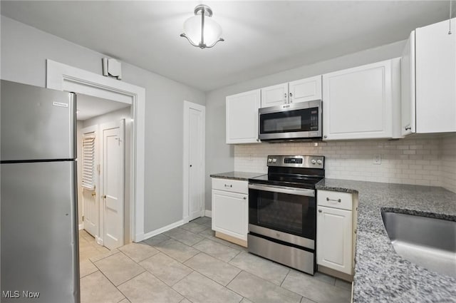 2484 Eaton Rd, University Heights, OH 44118 - kitchen featuring appliances with stainless steel finishes, tasteful backsplash, white cabinets, light tile patterned flooring, and baseboards