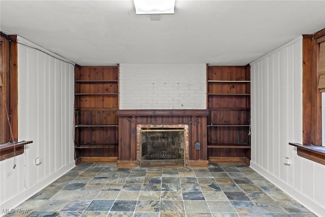 2484 Eaton Rd, University Heights, OH 44118 - unfurnished living room with a fireplace, stone finish floors, and a decorative wall