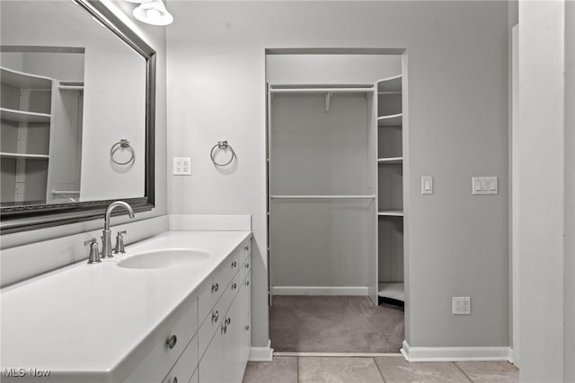 2484 Eaton Rd, University Heights, OH 44118 - bathroom featuring vanity, tile patterned floors, a walk in closet, and baseboards