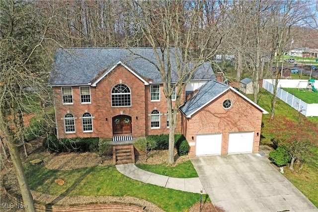 2248 Crestmont Dr, Girard, OH 44420 - colonial home with an attached garage, fence, concrete driveway, brick siding, and roof with shingles