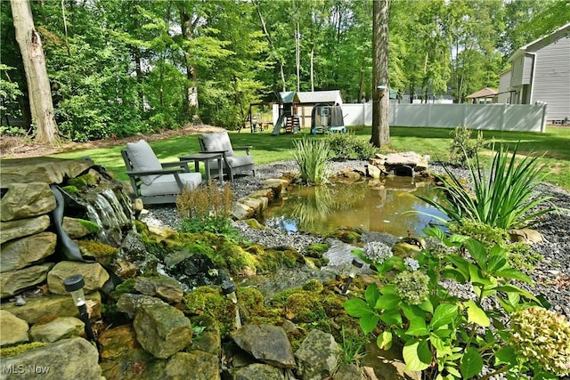 2248 Crestmont Dr, Girard, OH 44420 - view of yard featuring an outbuilding, fence, and a garden pond